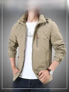 Detail view of khaki outdoor jacket showing windproof fabric and chest zipper pocket