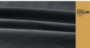 Détail du tissu confortable gris foncé du coupe-vent avec bande colorée
