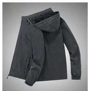 Vue latérale de la veste coupe-vent gris foncé avec capuche, poignets élastiques et poches zippées
