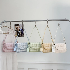 Detailed close-up of colorful checkered shoulder bags with cute cartoon prints and charms