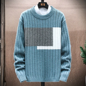 Detail of blue knit sweater with geometric color-block pattern and ribbed cuffs