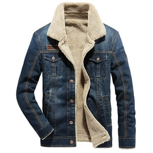 Detailed view of the warm beige faux shearling lining inside a navy blue denim jacket