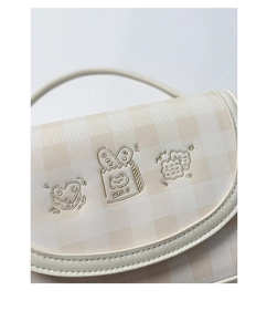 Close-up of checkered canvas bag with detailed bread and cake embroidery