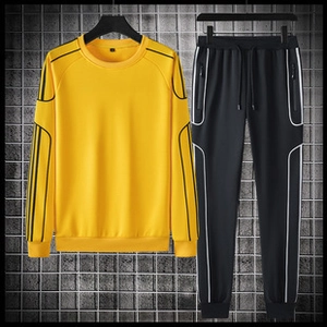 Detail view of yellow sweatshirt and black joggers set with side stripes on a grid background