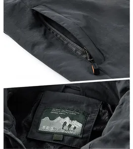 Détail de la veste de sport gris foncé avec poche zippée cachée et étiquette logo montagne