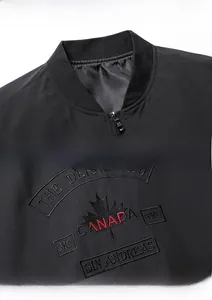 Dettaglio del colletto della giacca bomber nera con ricamo di foglia d'acero e Canada
