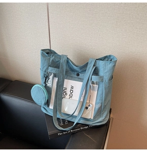 Detailed view of light blue nylon tote bag with transparent PVC pocket and round pouch