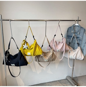Detail view of colorful canvas tote bags featuring star charms and adjustable straps