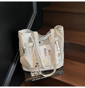 Detail of canvas tote bag with transparent PVC front pocket and mini coin purse attachment