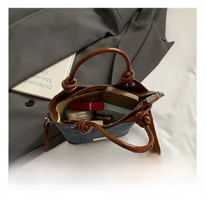 Vue détaillée de la capacité intérieure du sac seau en denim avec poignée en cuir