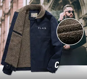 Detail of navy blue winter jacket showing warm brown lamb wool lining and PLAN chest print