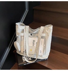Close-up of light gray nylon tote bag with transparent PVC pocket and small coin purse