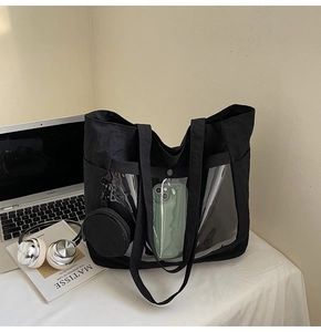 Detail of black canvas tote bag with a clear PVC front pocket and mini coin pouch