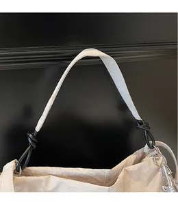 Detailed close-up of dual-material shoulder strap and knot design on beige canvas tote bag