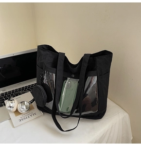 Detail view of black canvas tote bag with transparent PVC pocket and round coin purse