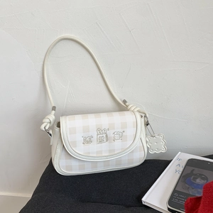 Detail of cream shoulder bag with check pattern and cute cartoon bread embroidery