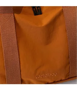 Détail du sac de voyage en nylon orange montrant la texture et le logo brodé