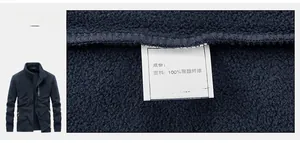 Gros plan de l'étiquette et du tissu 100% polyester sur la veste polaire bleue