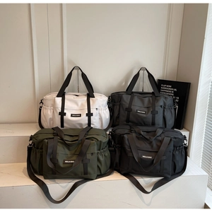 Présentation étagée de grands sacs de voyage en blanc, gris, vert et noir nylon