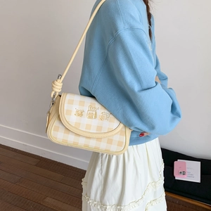 Detail showing checkered patterns and cute cartoon characters on a crossbody bag