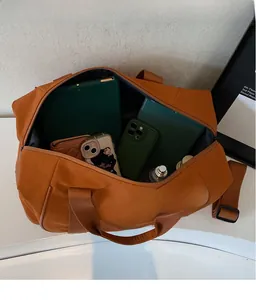 Sac de voyage orange caramel montrant un grand espace pour tablette et accessoires