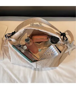 Top view of spacious interior of a beige canvas tote bag with various daily essentials