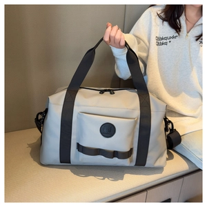 Close-up of lightweight grey travel duffel bag with handles and detachable shoulder strap