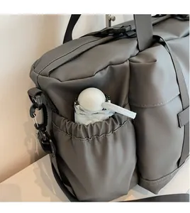 Détail de la poche latérale élastique sur ce sac de voyage gris en nylon avec un parapluie