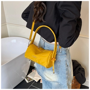 Close-up of a bright yellow textured leather boston bag with drawstring tassel details