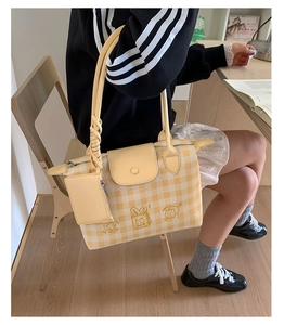Detail of yellow checkered tote bag with cute cartoon embroidery for casual styling