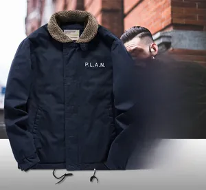 Detail of navy fleece-lined jacket with brown lamb wool collar and P.L.A.N. print