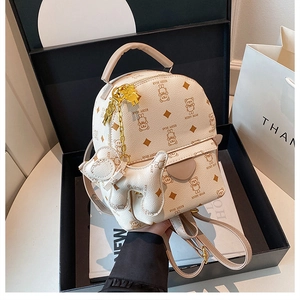 Unboxing of a cream mini backpack with bear print and gold chain in a premium gift box