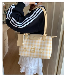 Close-up of yellow plaid tote bag featuring cute cake embroidery and matching small card pouch