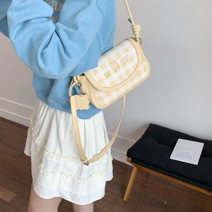 Detail of yellow checkered armpit bag with cute animal print and biscuit charm
