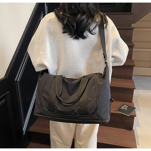 Détail d'un grand sac de sport noir montrant le tissu imperméable et le compartiment chaussures
