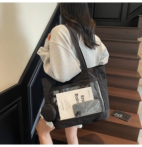 Detail of black nylon tote bag with transparent front pocket and mini round coin purse