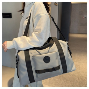 Detail of grey travel duffel bag showing reinforced straps and front pocket