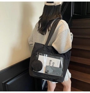 Detail of black nylon ita bag with transparent PVC window and small round side pouch