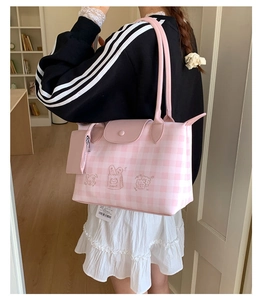 Detail of pink plaid tote with cat embroidery and matching small pouch on shoulder