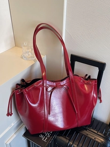 Minimalist glossy burgundy tote bag with leather bow and drawstring closure detail