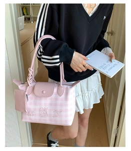 Detail view of pink plaid tote bag with cartoon embroidery and matching mini pouch