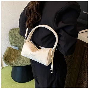 Detail of cream pleated cylinder bag with drawstring fringe and fashion lettering