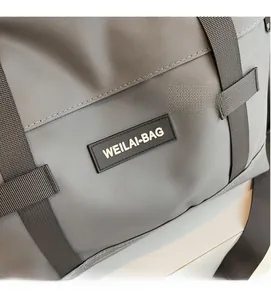 Gros plan du tissu gris du sac de voyage avec logo de marque en caoutchouc