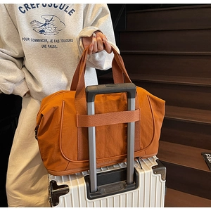 Sac de voyage orange avec passant pour trolley et compartiment chaussures sur valise