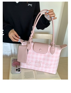 Detail of pink plaid tote bag with cake prints and woven handle decoration