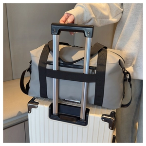 Gray travel bag sleeve securely attached to a suitcase handle for easy boarding