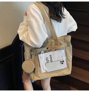 Detail view of khaki canvas ita bag with clear PVC pocket and small round pouch