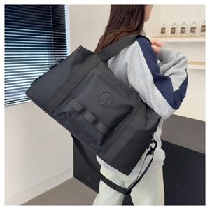 Close-up of black high-density waterproof nylon travel bag with logo and adjustable strap