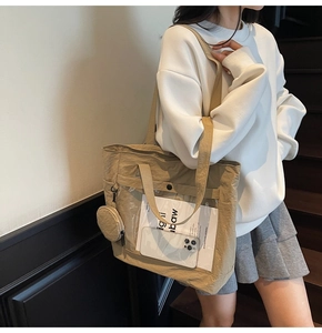 Detail of khaki large canvas tote bag with transparent front pocket and small coin purse