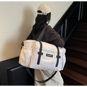 Vue de dos d'une personne portant un grand sac de voyage blanc avec des sangles noires